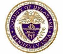 Seal of Delaware County, Pennsylvania, featuring an eagle, shield, and decorative elements in purple and gold.